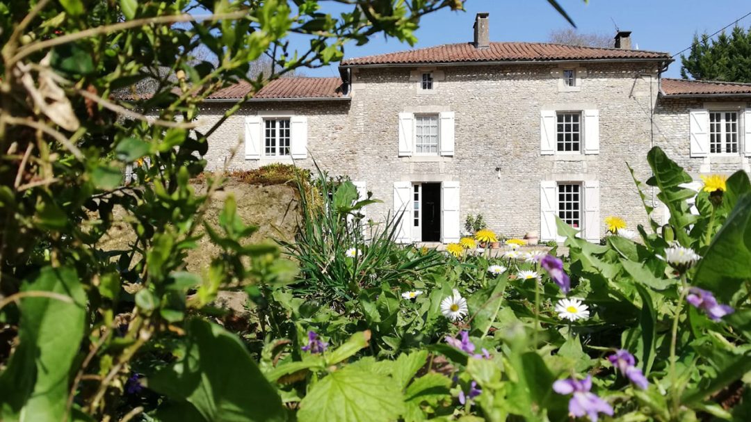 Façade du Moulin avec des fleurs au premier plan